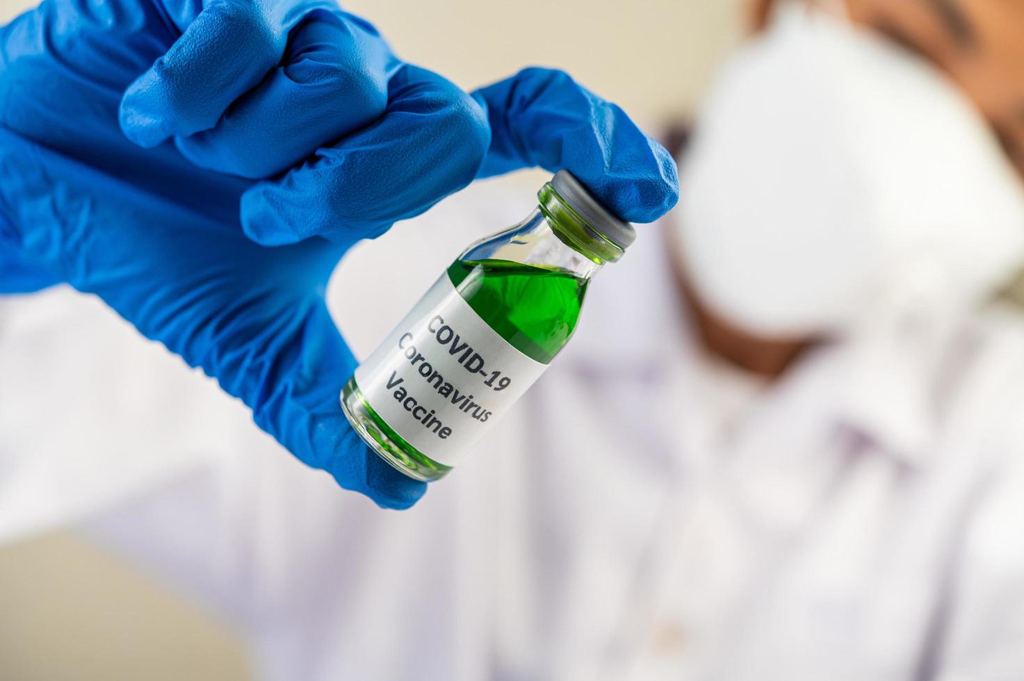 wetenschapper aan tafel met vaccins en medicijnen foto