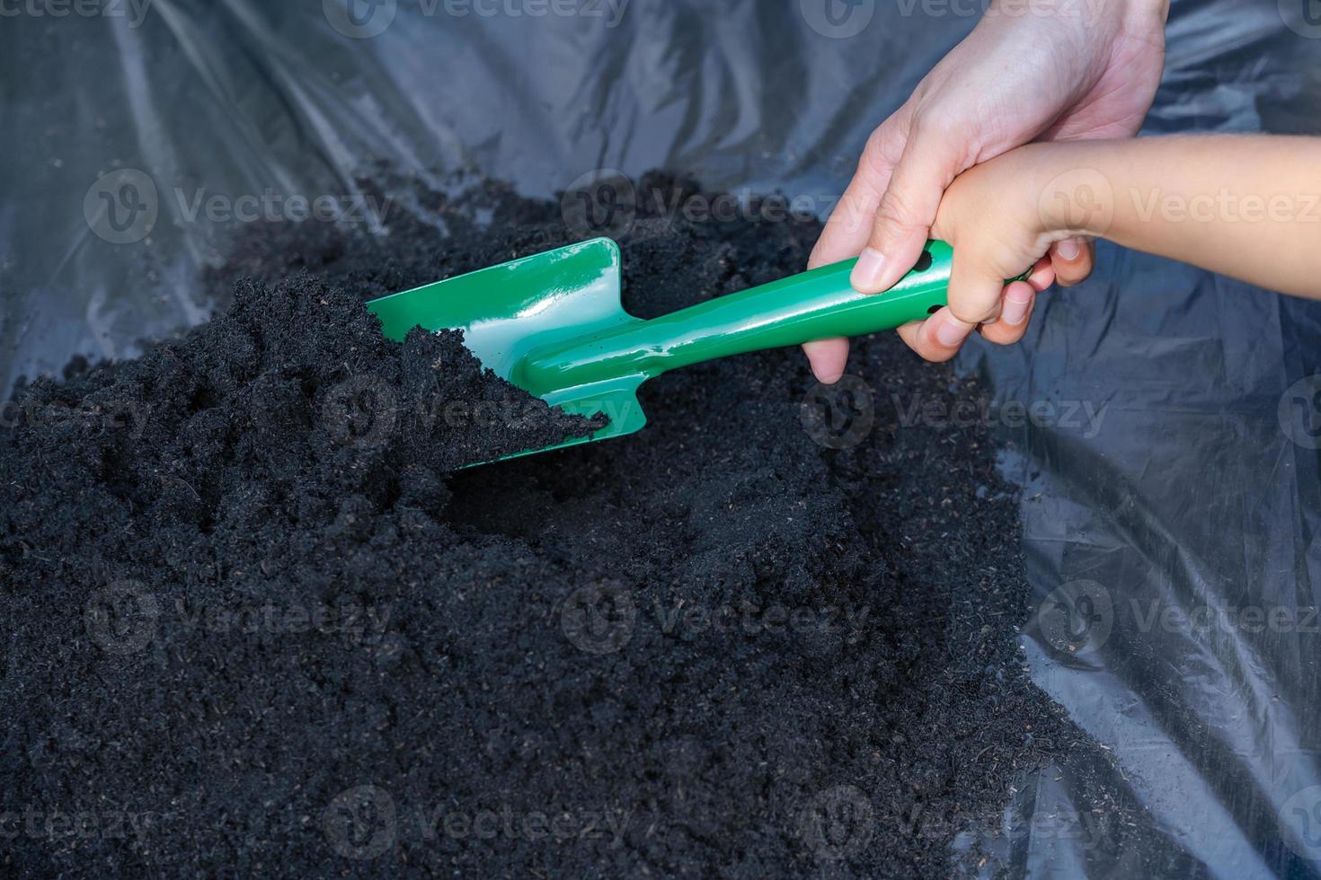 detailopname van kleuter zoon en moeder hand- onderwijs weinig zoon voorbereidingen treffen bodem naar fabriek in tuin, moeder en zoon relatie. mama's weinig helper. tuinieren. vrije tijd activiteiten concept foto