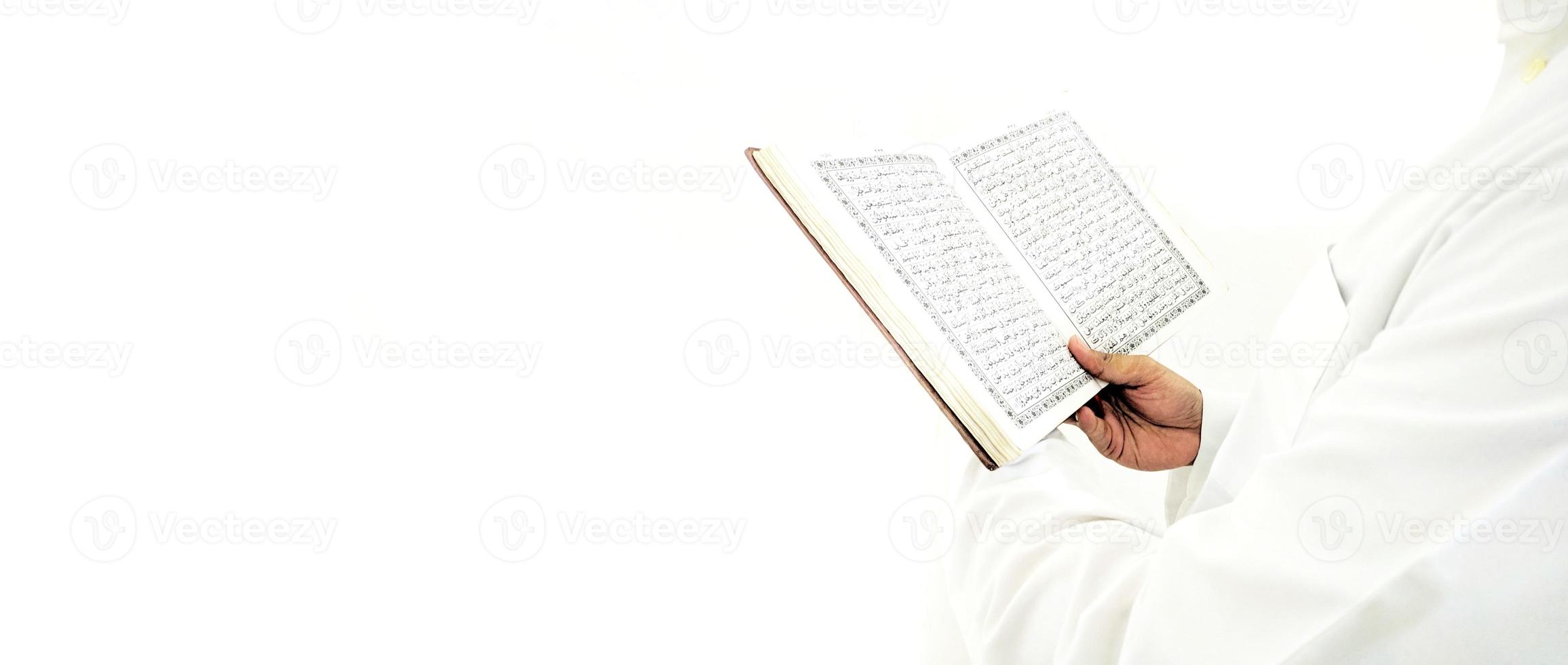 man die de koran vasthoudt en leest. islamitische achtergrond foto