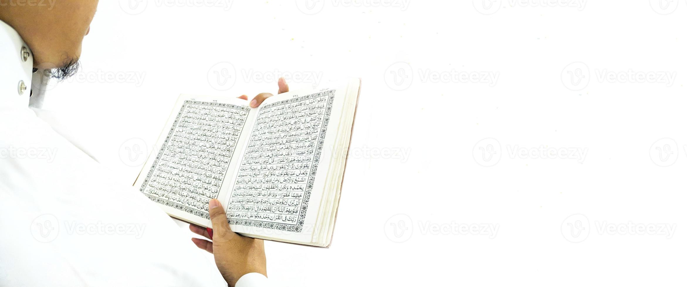 man die de koran vasthoudt en leest. islamitische achtergrond foto