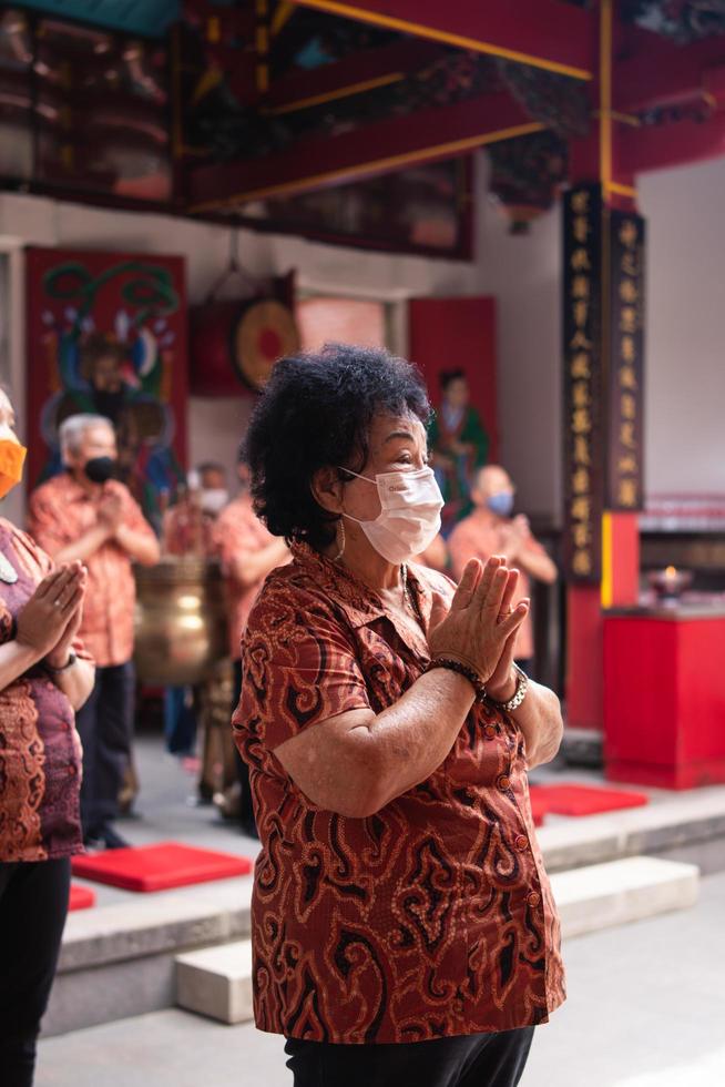 bandoeng, Indonesië, 2020 - de bezoeker bidden samen met de monniken in voorkant van de aanbiedingen naar de god foto