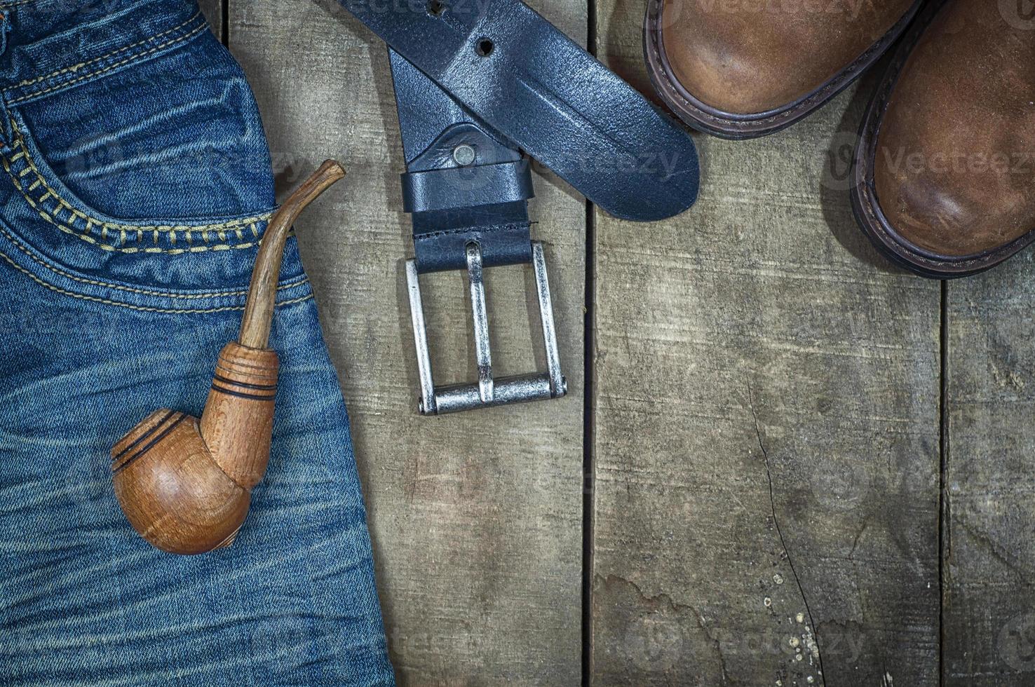 detail van versleten blauw jeans en bruin schoenen Aan een houten achtergrond foto