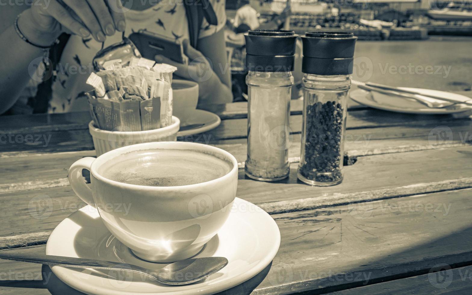 kopje koffie op oude houten tafel restaurant aan de kust. foto