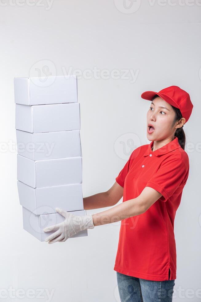 beeld van jong levering Mens in rood pet blanco t-shirt uniform staand met leeg wit karton doos geïsoleerd Aan licht grijs achtergrond studio foto