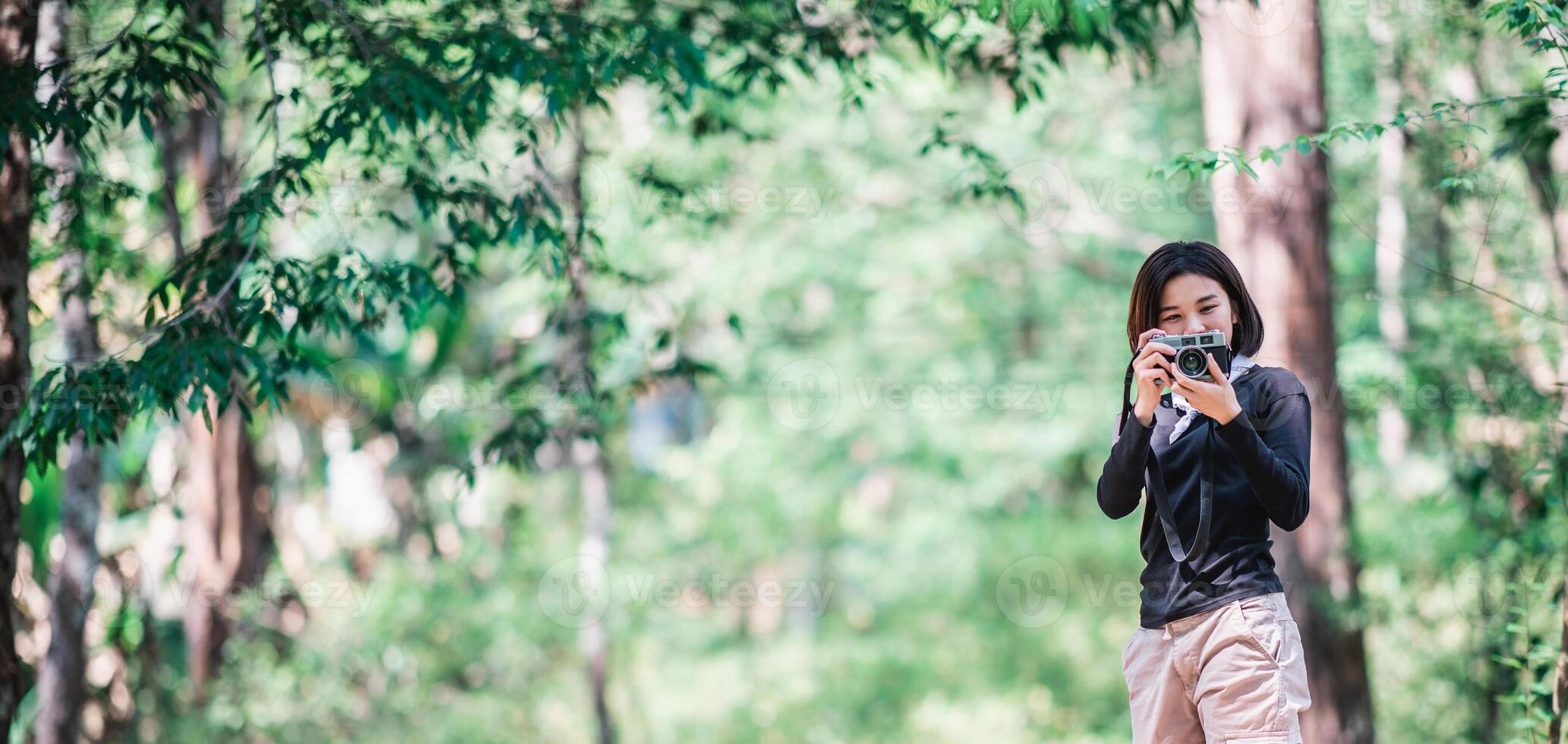 jong mooi vrouw gebruik camera nemen foto in natuur park