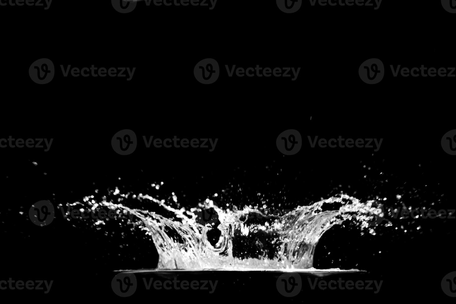 spatten water Aan een zwart achtergrond. water plons verfrissend zwart achtergrond foto