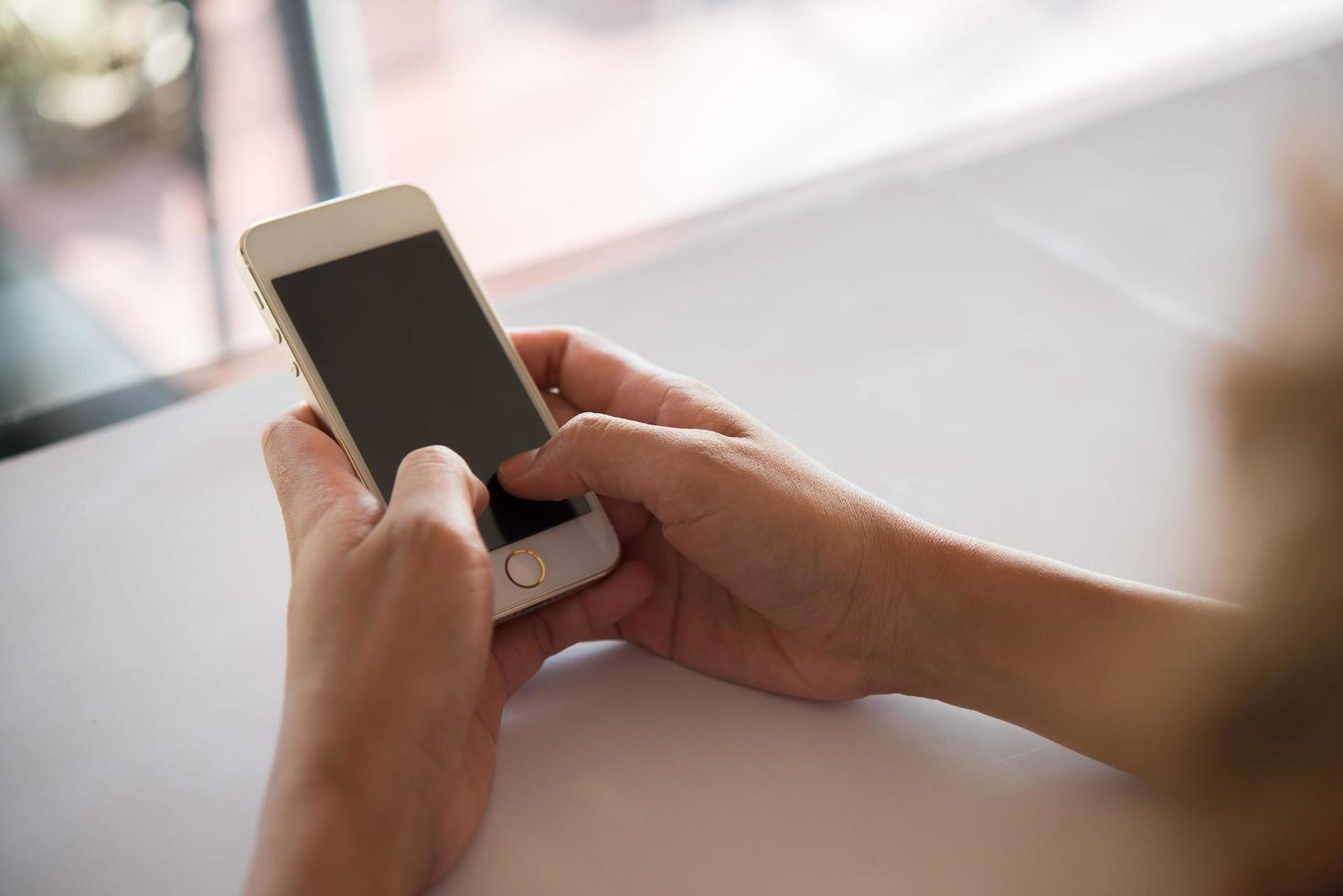 close-up van de hand van een vrouw met behulp van een mobiele telefoon foto