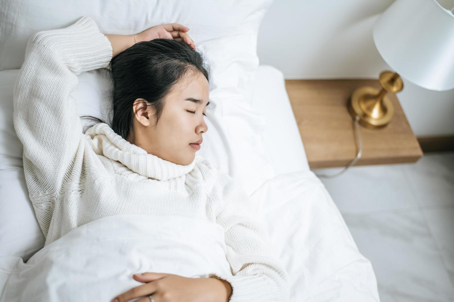 jonge vrouw, gekleed in een wit overhemd, net wakker in bed foto