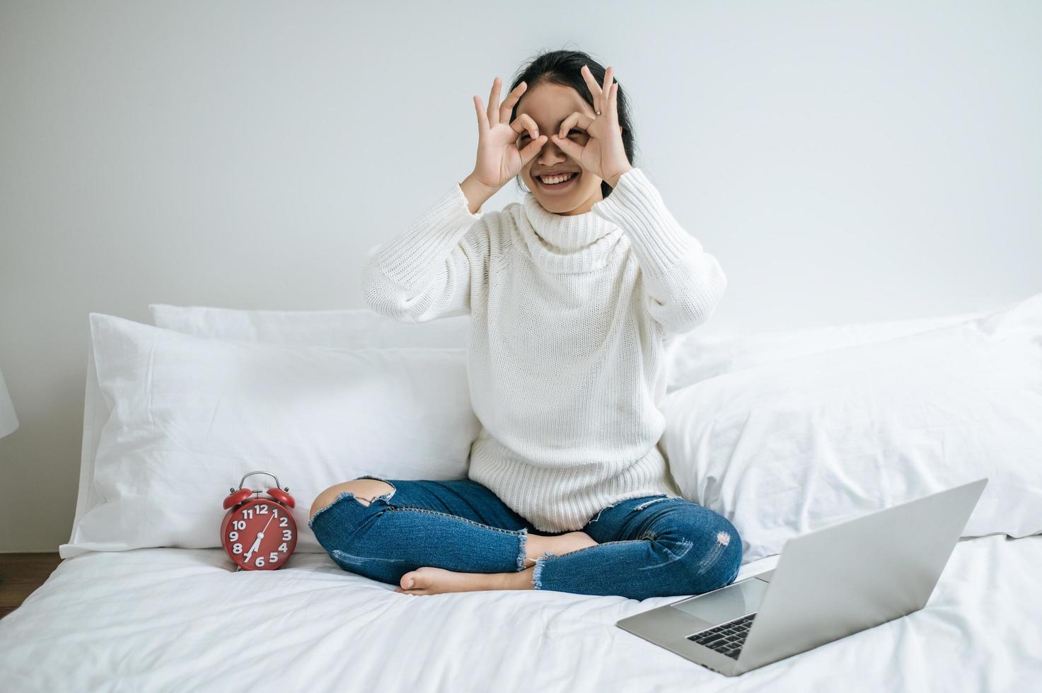 jonge vrouw zittend op haar bed gelukkig lachend foto