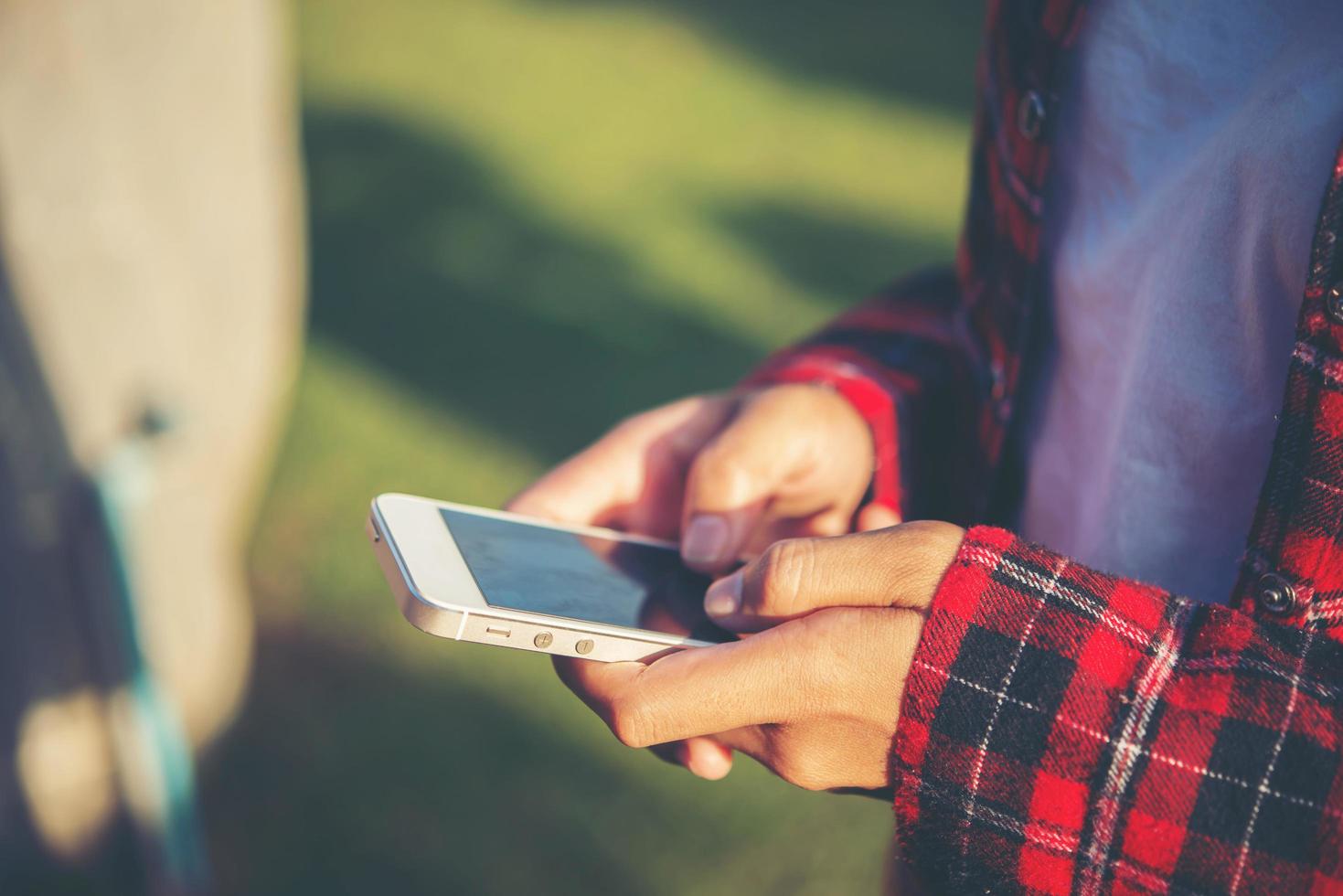 jonge vrouw met behulp van een smartphone buiten in een park foto