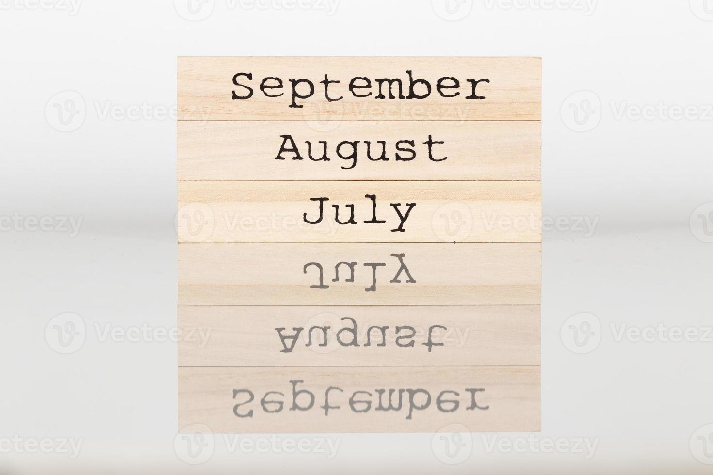 houten kubus met de opschrift juli, augustus, september Aan een wit achtergrond foto