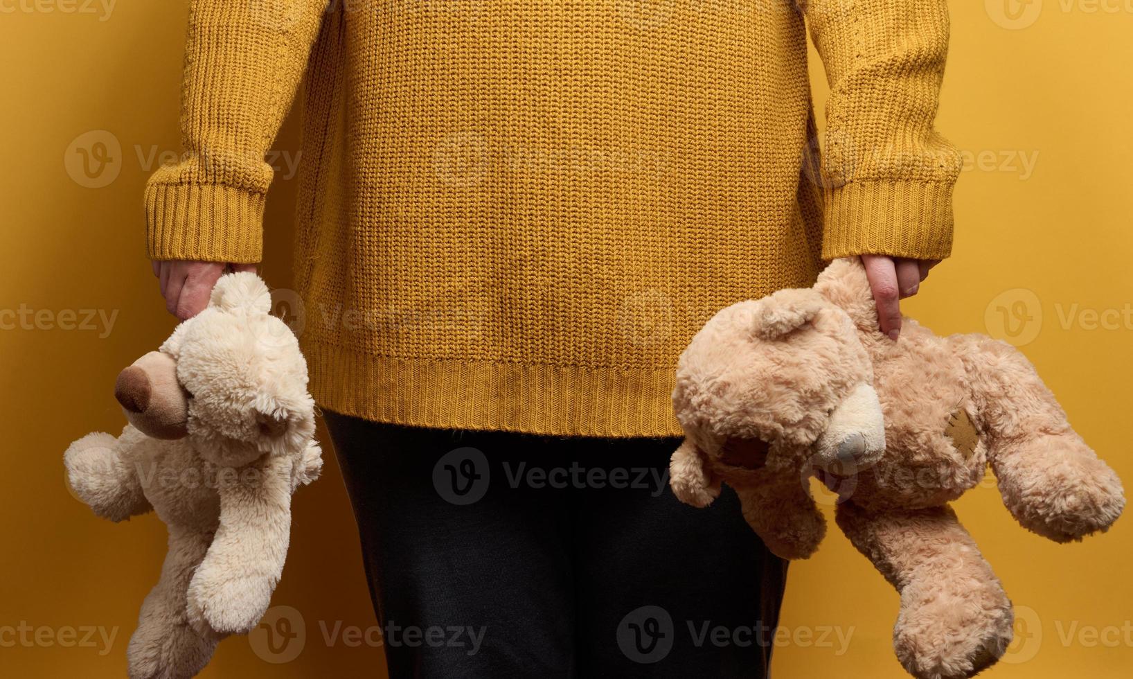 vrouw in oranje gebreid trui Holding schattig bruin teddy beer. de concept van eenzaamheid en droefheid, depressie foto