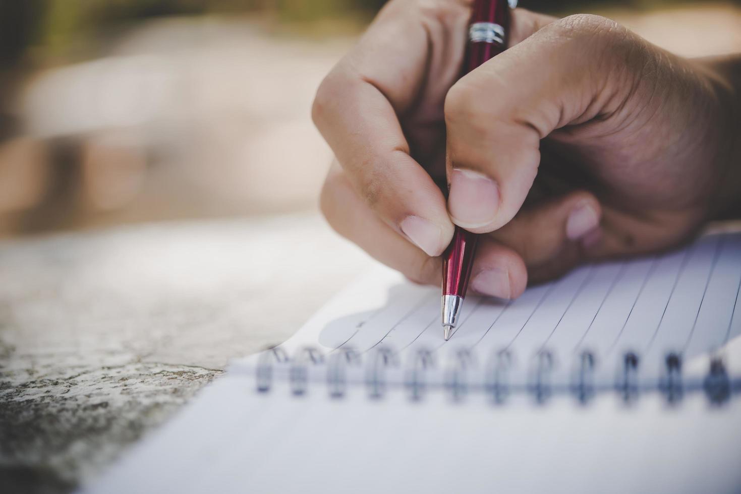 man handschrift in zijn notitieblok foto