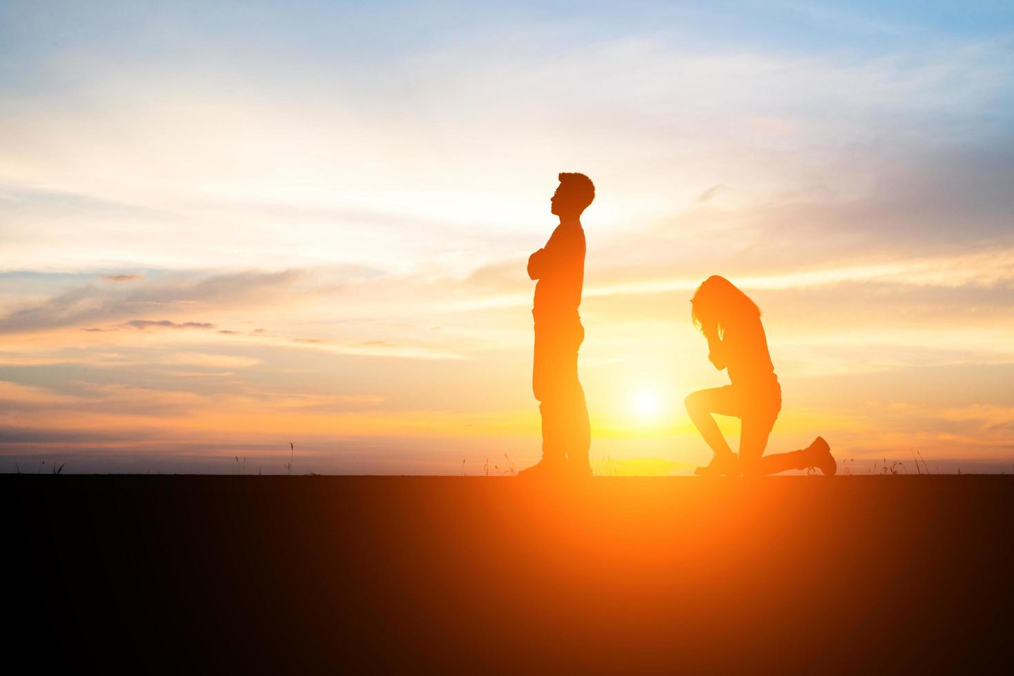 silhouet van een boos paar in een ruzie bij zonsondergang foto