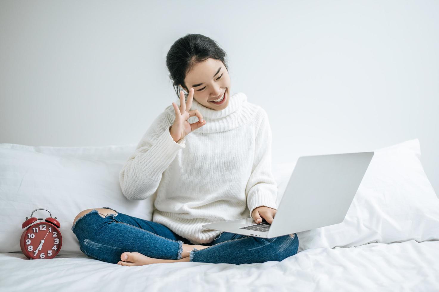 jonge vrouw die een wit overhemd draagt dat op haar laptop speelt foto