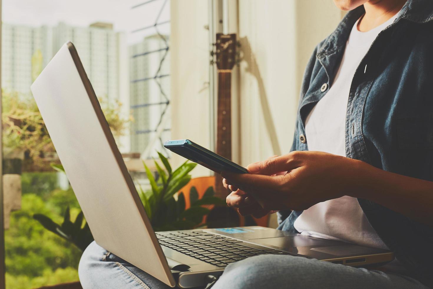 vrouw met behulp van telefoon en laptop foto