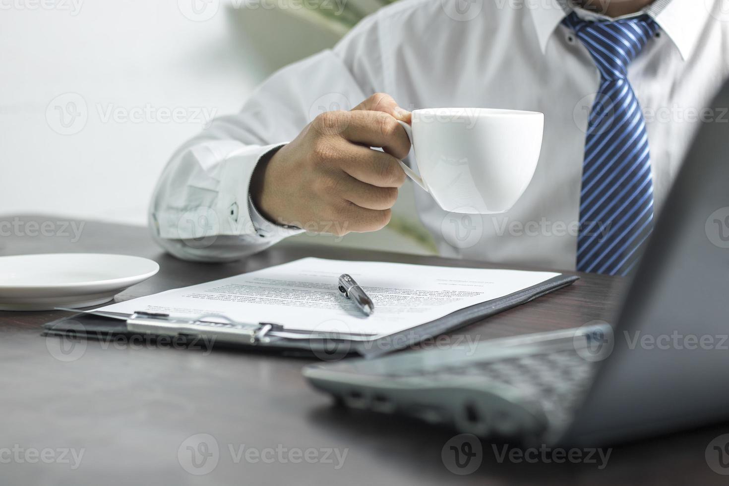 persoon in een stropdas met een kopje koffie foto