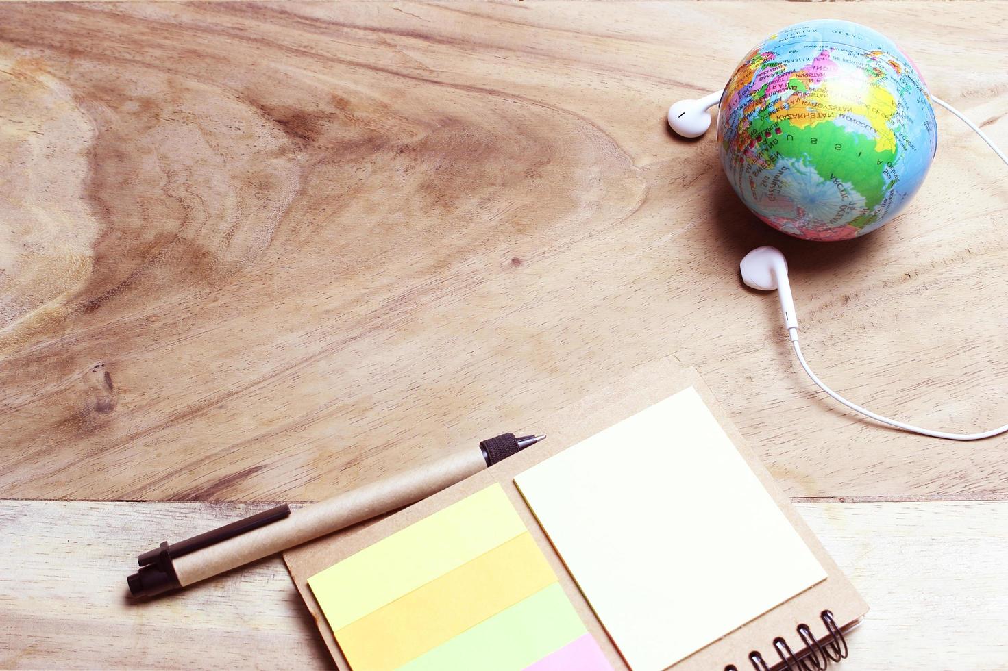 wereldbol en oortelefoons op bureau foto