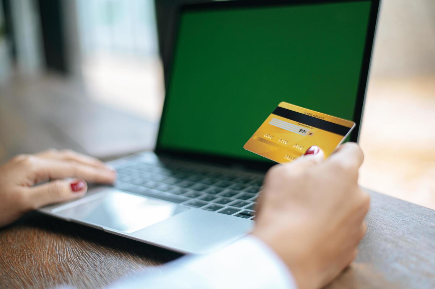 vrouw met een laptop en een creditcard foto