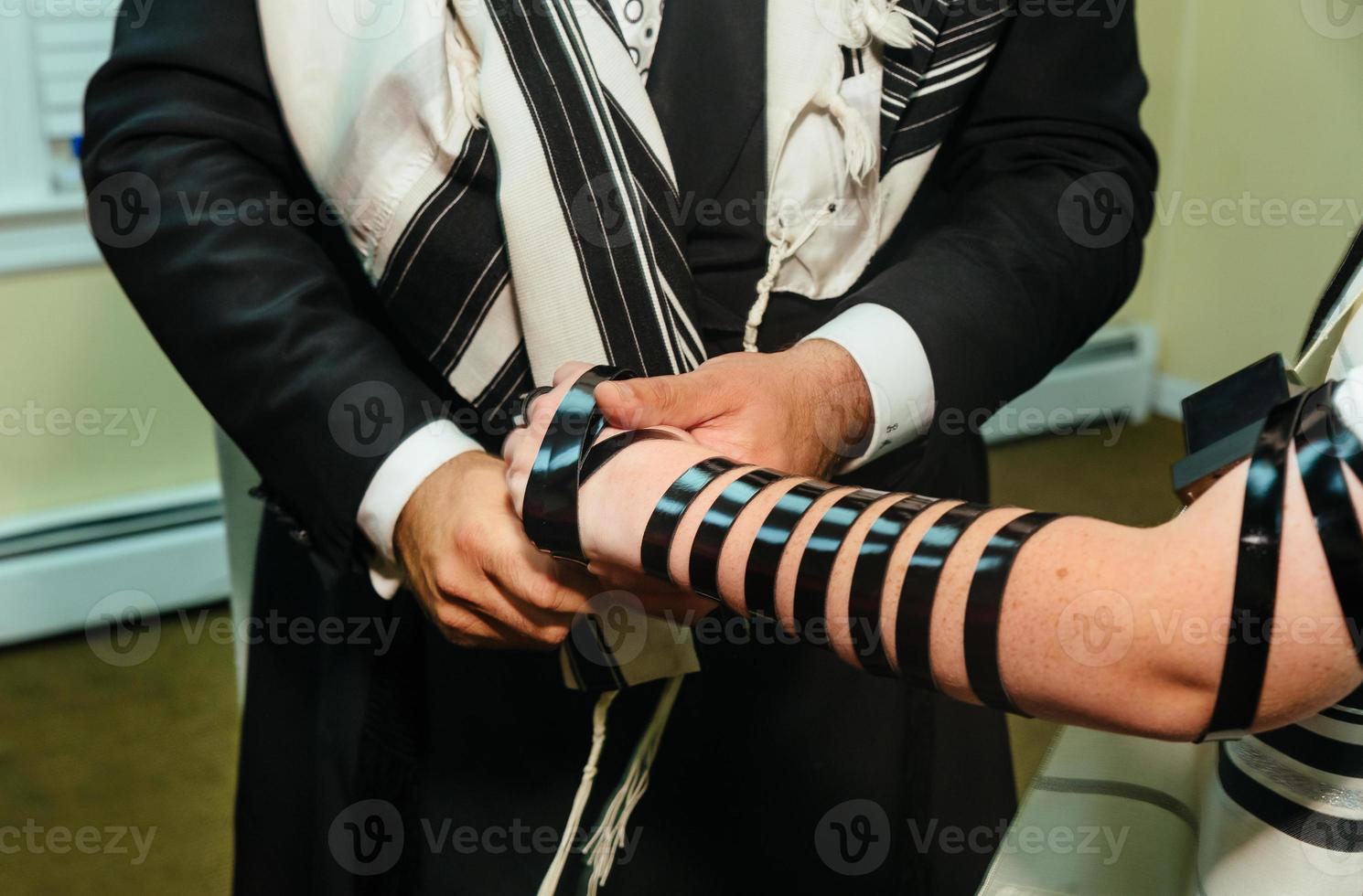 hand van jongen die de joodse torah leest bar mitswa foto