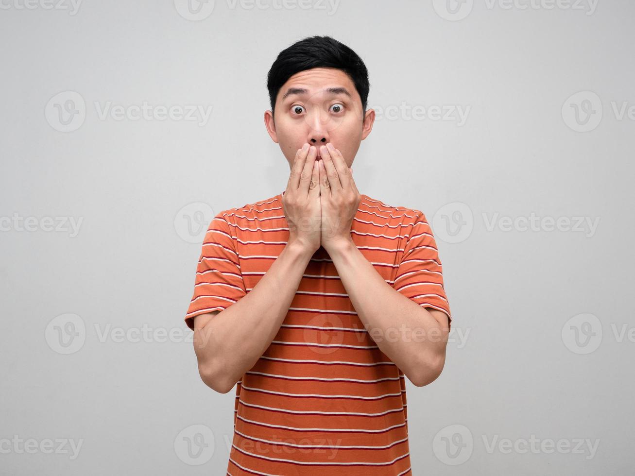 Aziatisch Mens oranje gestreept voelt versteld staan gebaar dichtbij zijn mond geïsoleerd foto