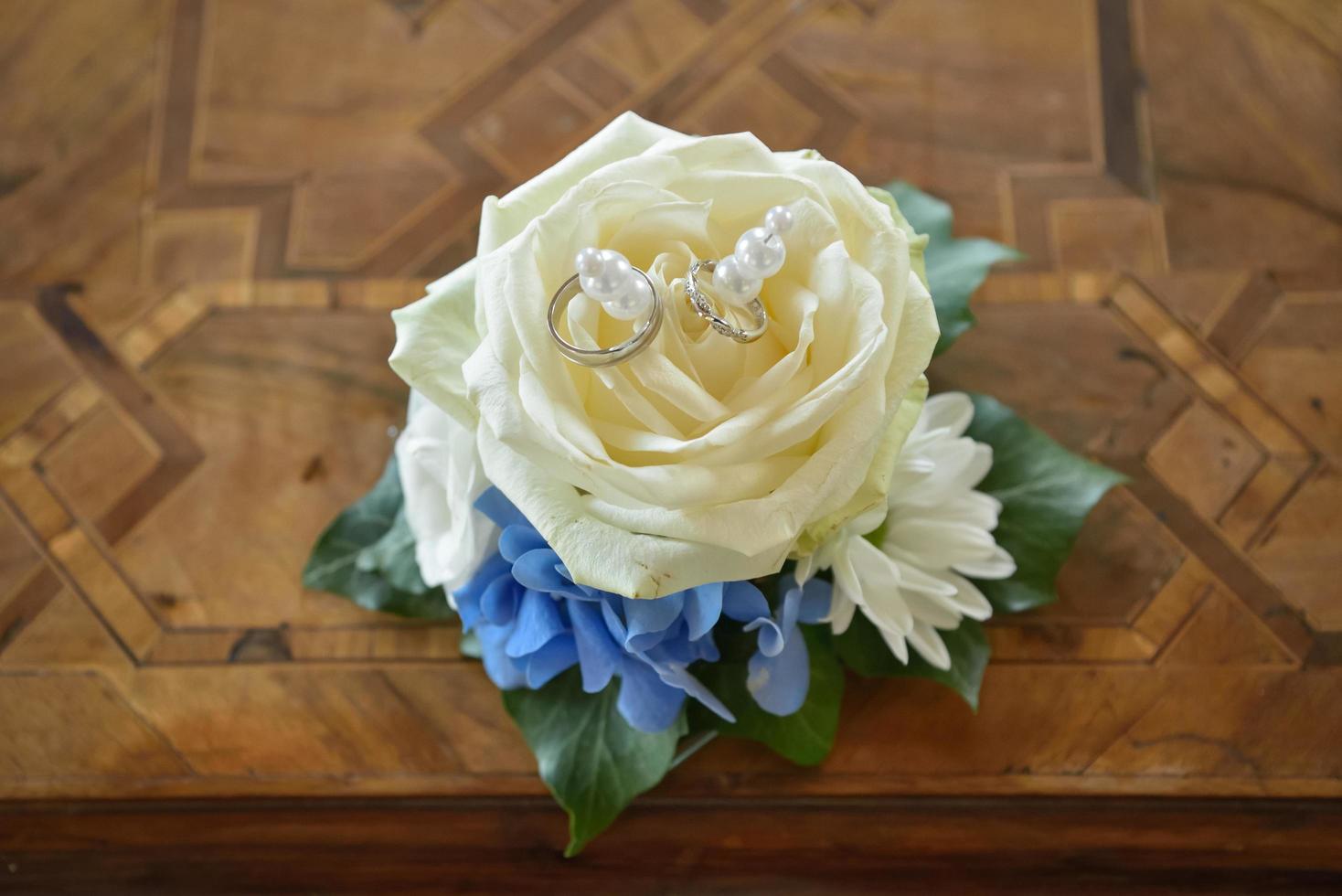 trouwringen op witte roos foto