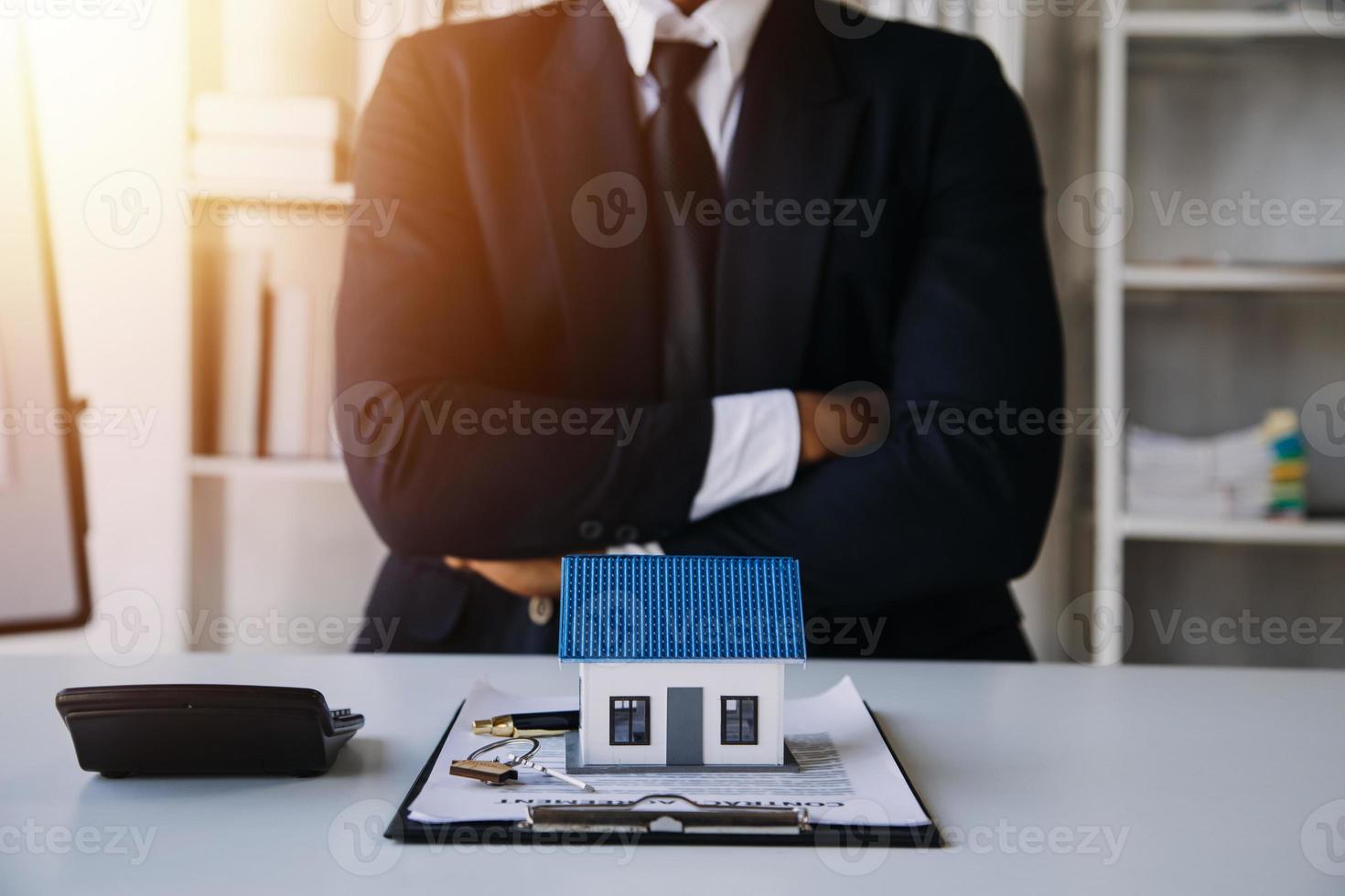 makelaar in onroerend goed levert een voorbeeld van een modelhuis aan de klant, hypotheekovereenkomst maken van lease en kopen en verkopen huis en contract woningverzekering hypothecaire lening concept foto