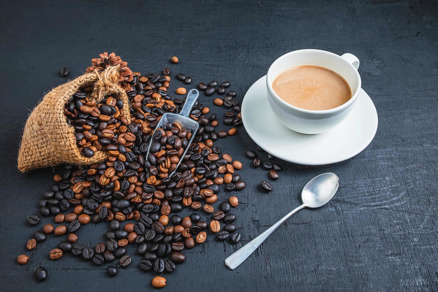 kopje koffie met koffiebonen op een donkere achtergrond foto