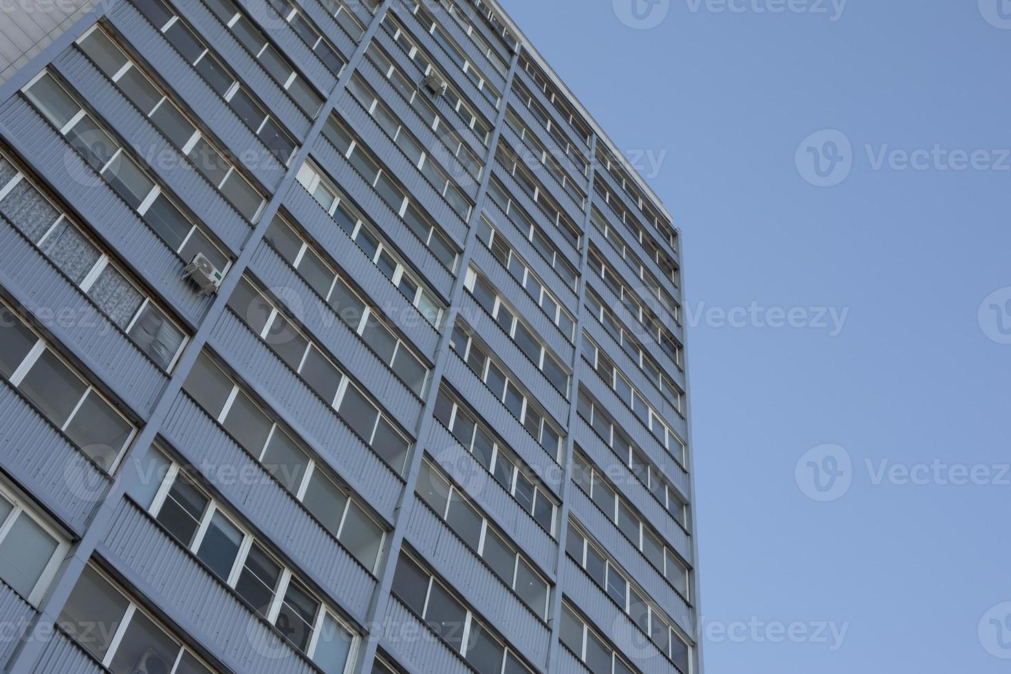 grijs gebouw met ramen. hoog gebouw in stad. veel van ramen. foto