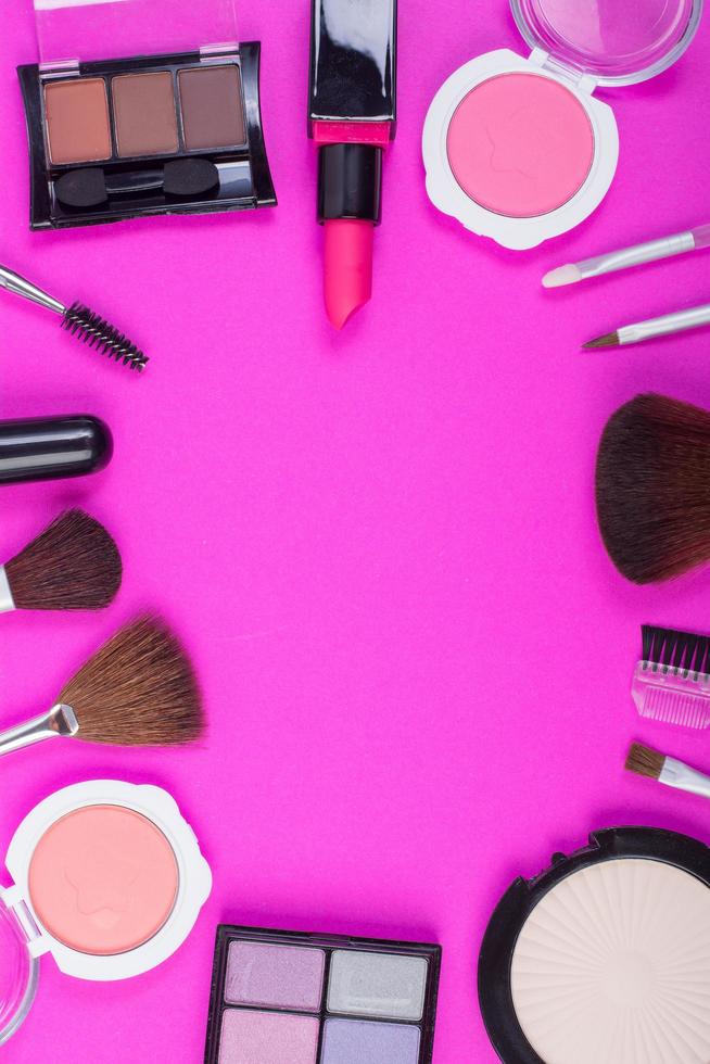 bovenaanzicht van een verzameling cosmetische schoonheidsproducten op een roze achtergrond foto