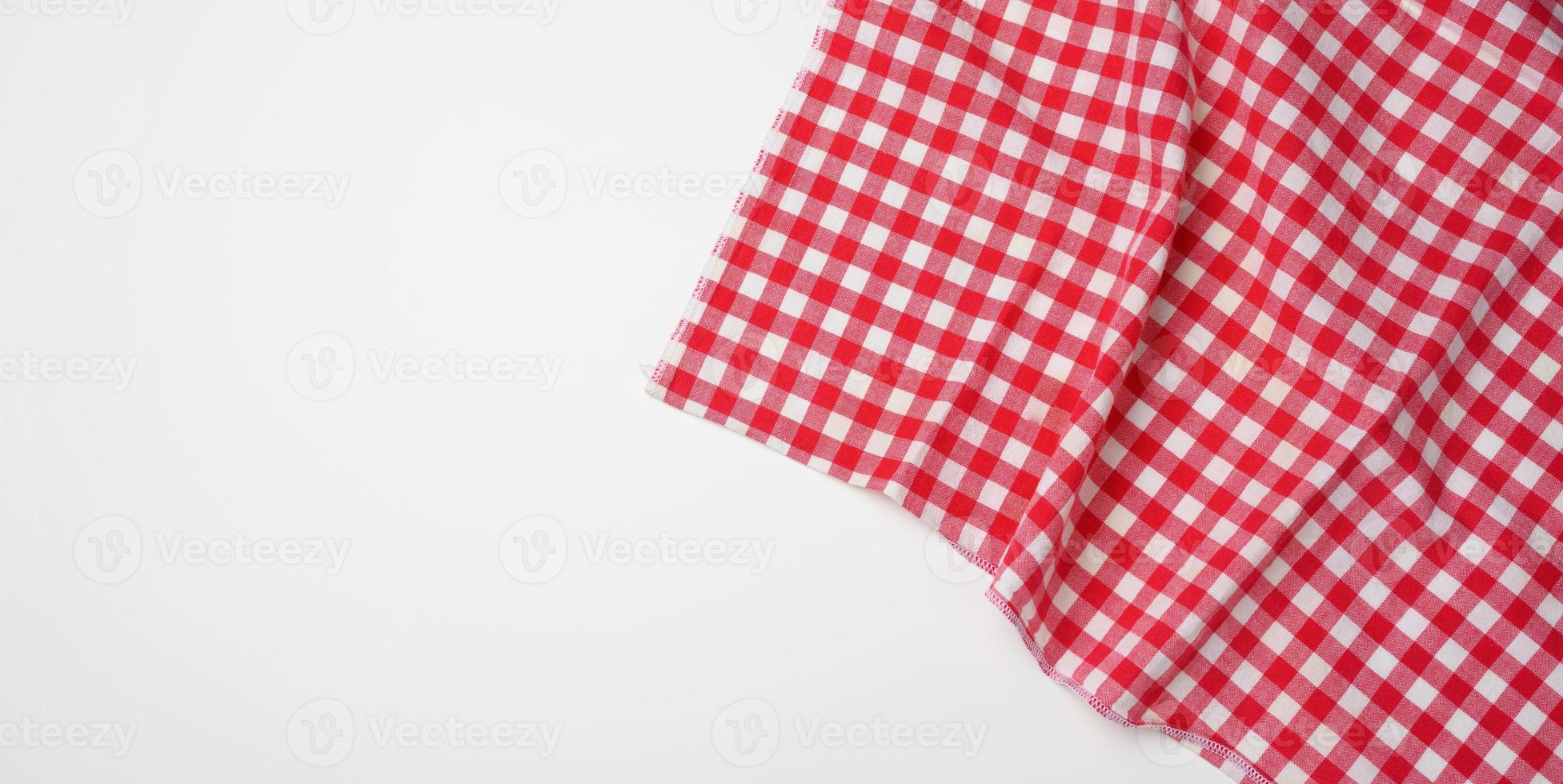gevouwen katoen rood wit geruit servet Aan een wit achtergrond foto
