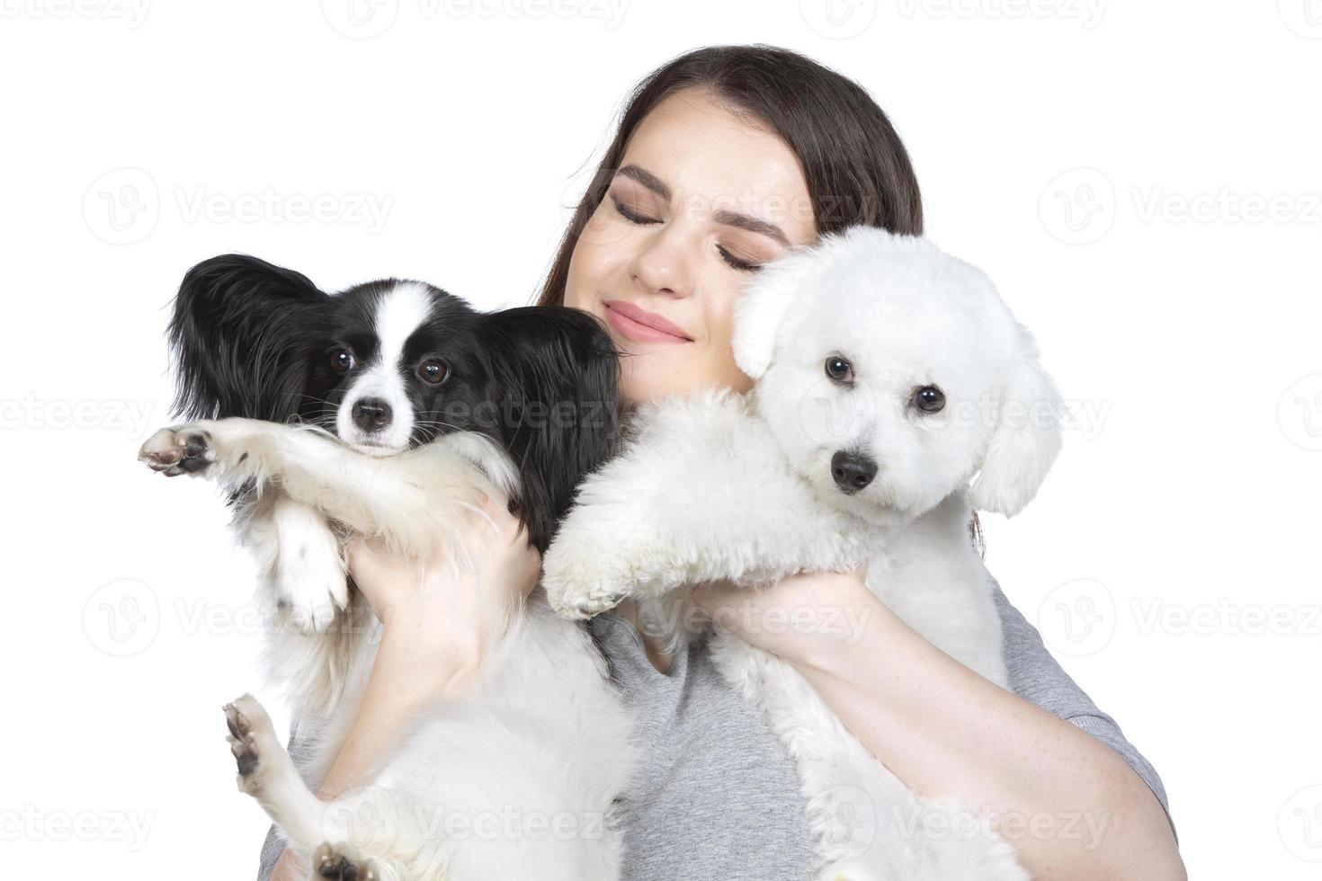 een schattig jong vrouw is Holding haar papillon en bichon pup. liefde tussen eigenaar en hond. de meisje Toneelstukken met de honden. huisdieren. foto