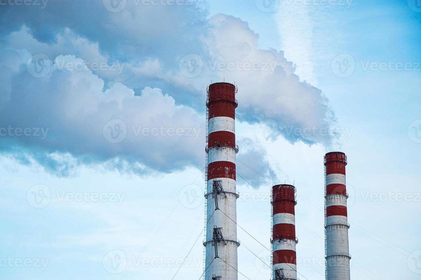 luchtvervuiling. rokende schoorstenen tegen blauwe hemel. foto