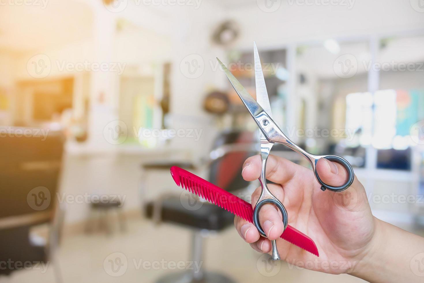 kapper houdt een schaar vast met salon schoonheidsachtergrond foto