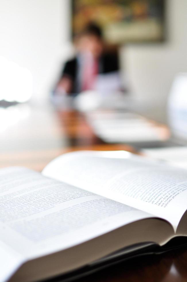 open boek op een bureau met een wazige man op de achtergrond foto