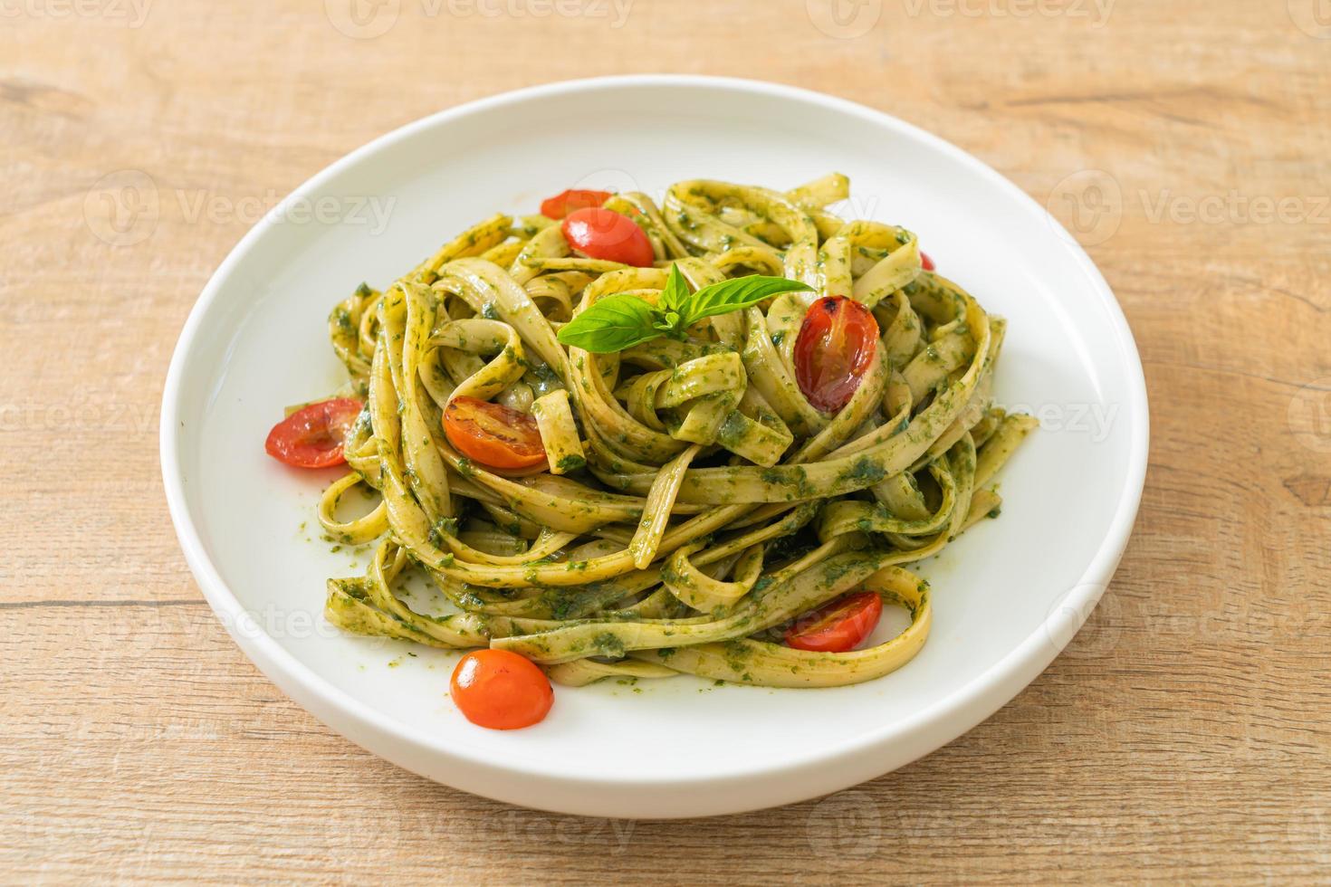 fettuccine spaghetti pasta met pestosaus en tomaten foto