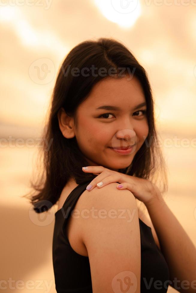 een Aziatisch tiener- vrouw met een zwart overhemd en zwart haar- heeft een schattig gezicht wanneer ze glimlacht en geniet de visie foto