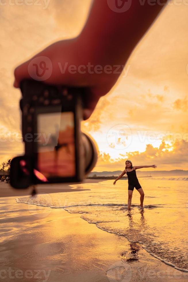 een camera foto's een Aziatisch vrouw aan het doen een ballet dans eenzaam Aan de strand foto