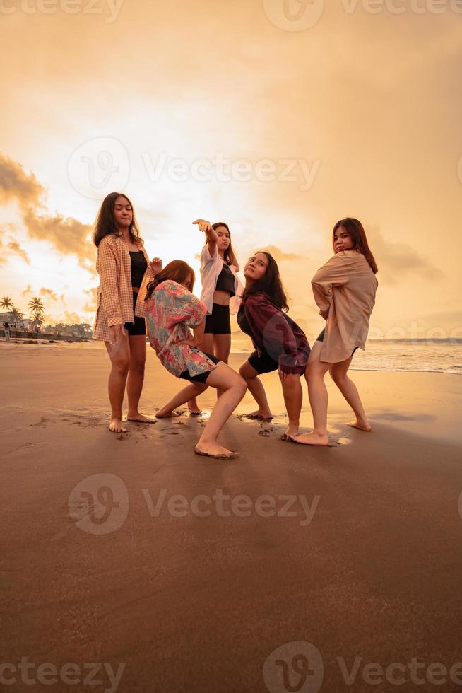 een groep van Indonesisch Dames genieten de strand gelukkig wanneer ze ontmoeten hun vrienden Bij de vakantie moment foto