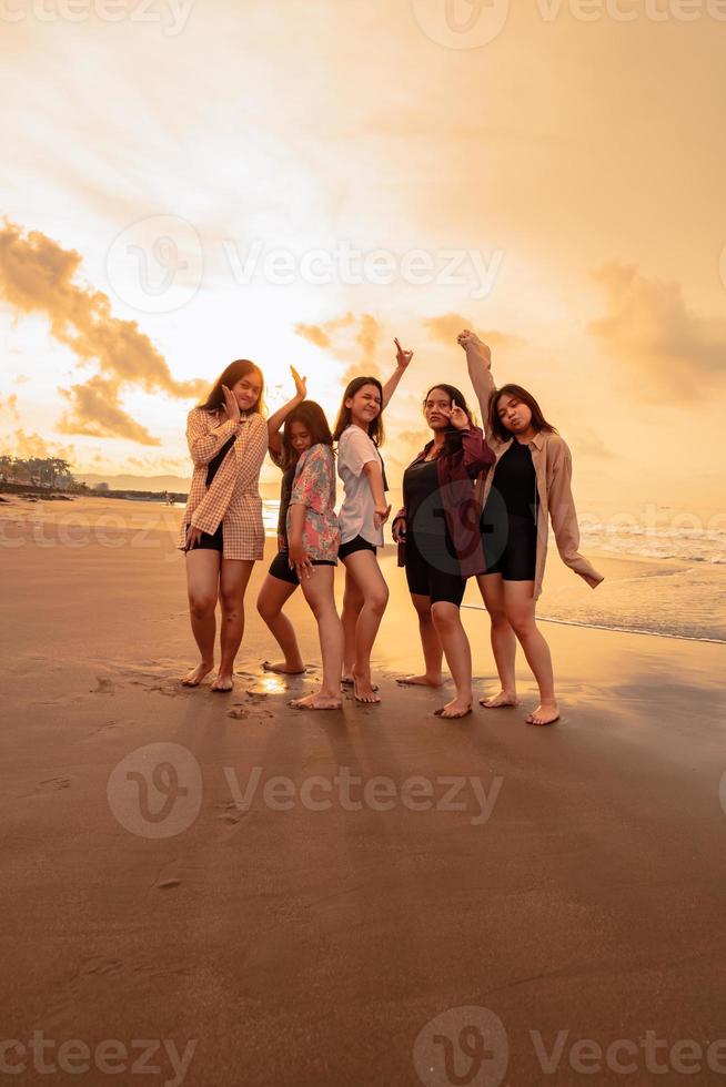 een groep van Indonesisch Dames genieten de strand gelukkig wanneer ze ontmoeten hun vrienden Bij de vakantie moment foto