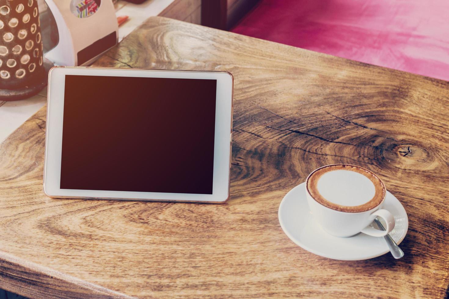 koffie en tablet computer Aan tafel met wijnoogst toon. foto