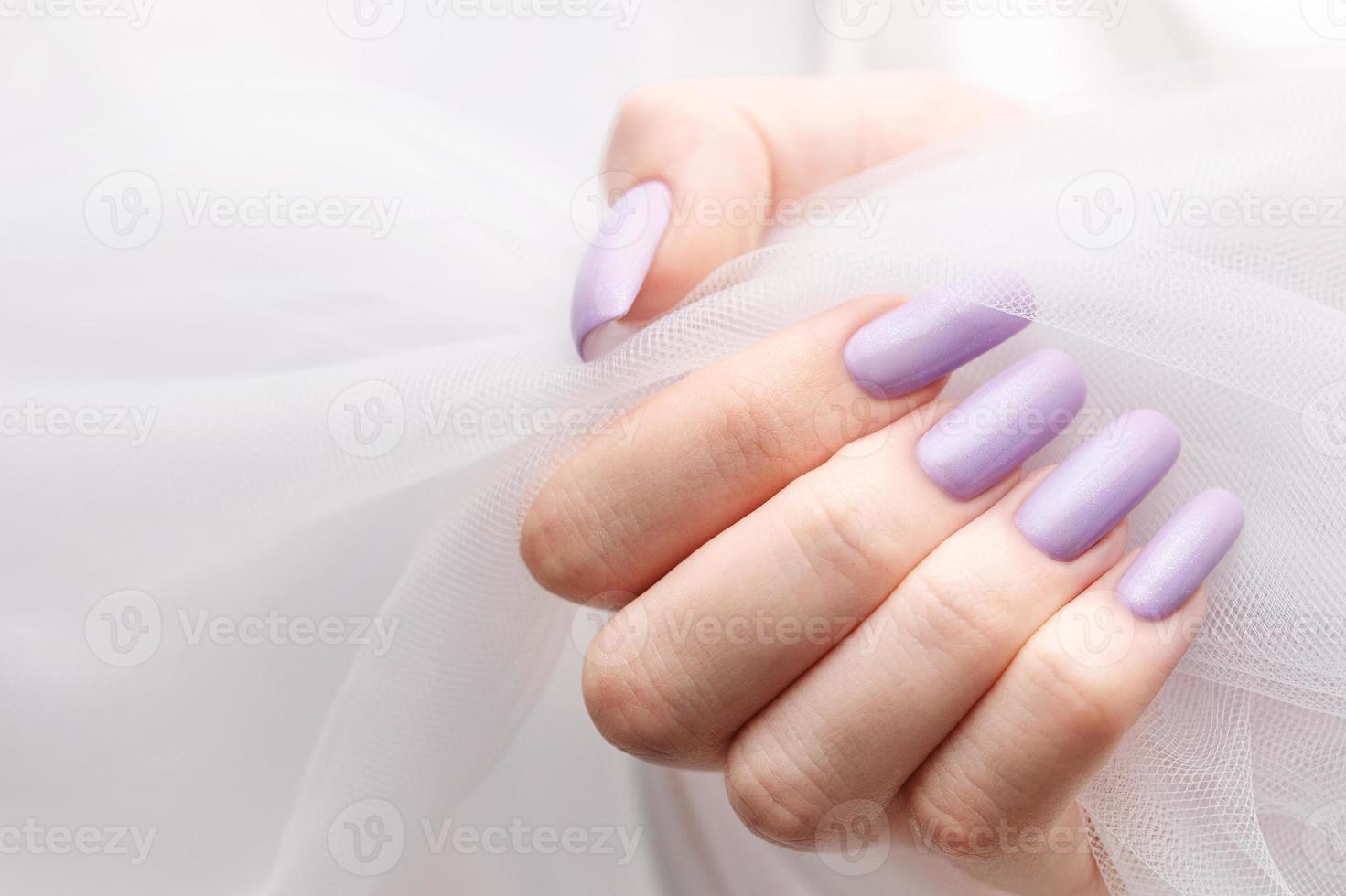 meisjes handen met een zacht Purper manicuren. foto