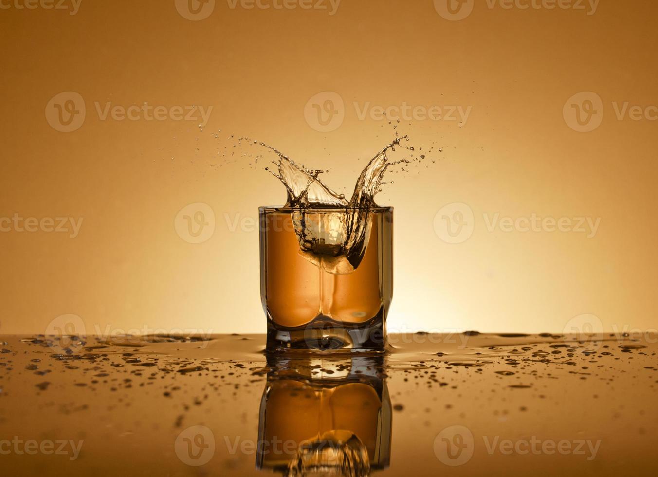 een glas van alcoholisch drinken Aan een gouden achtergrond foto