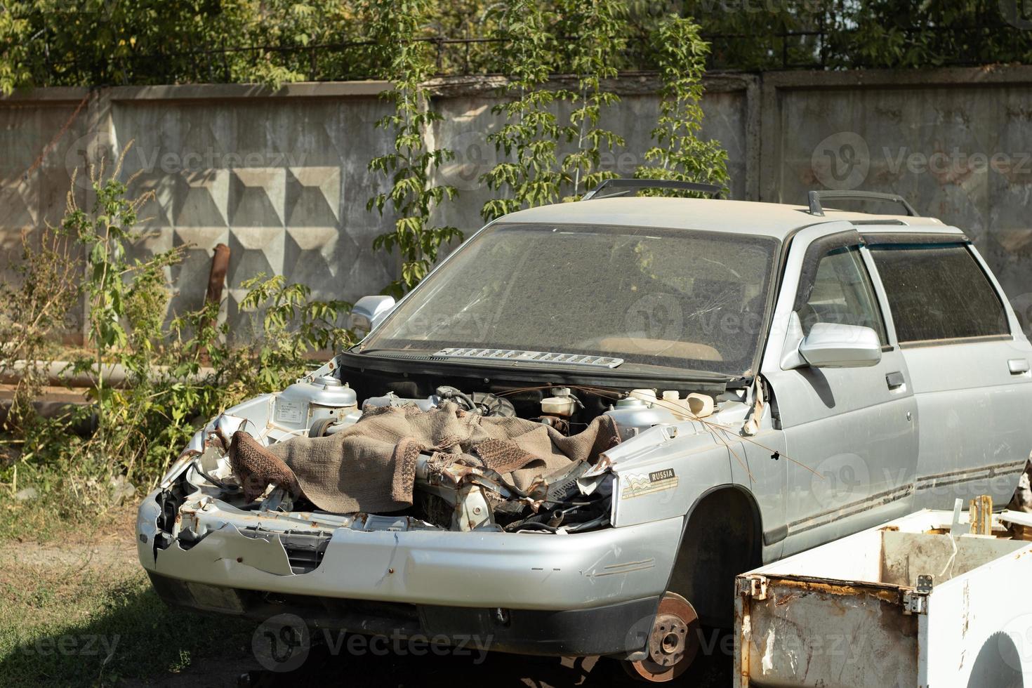 oud auto met de kap verwijderd voor schroot. auto motor reparatie foto