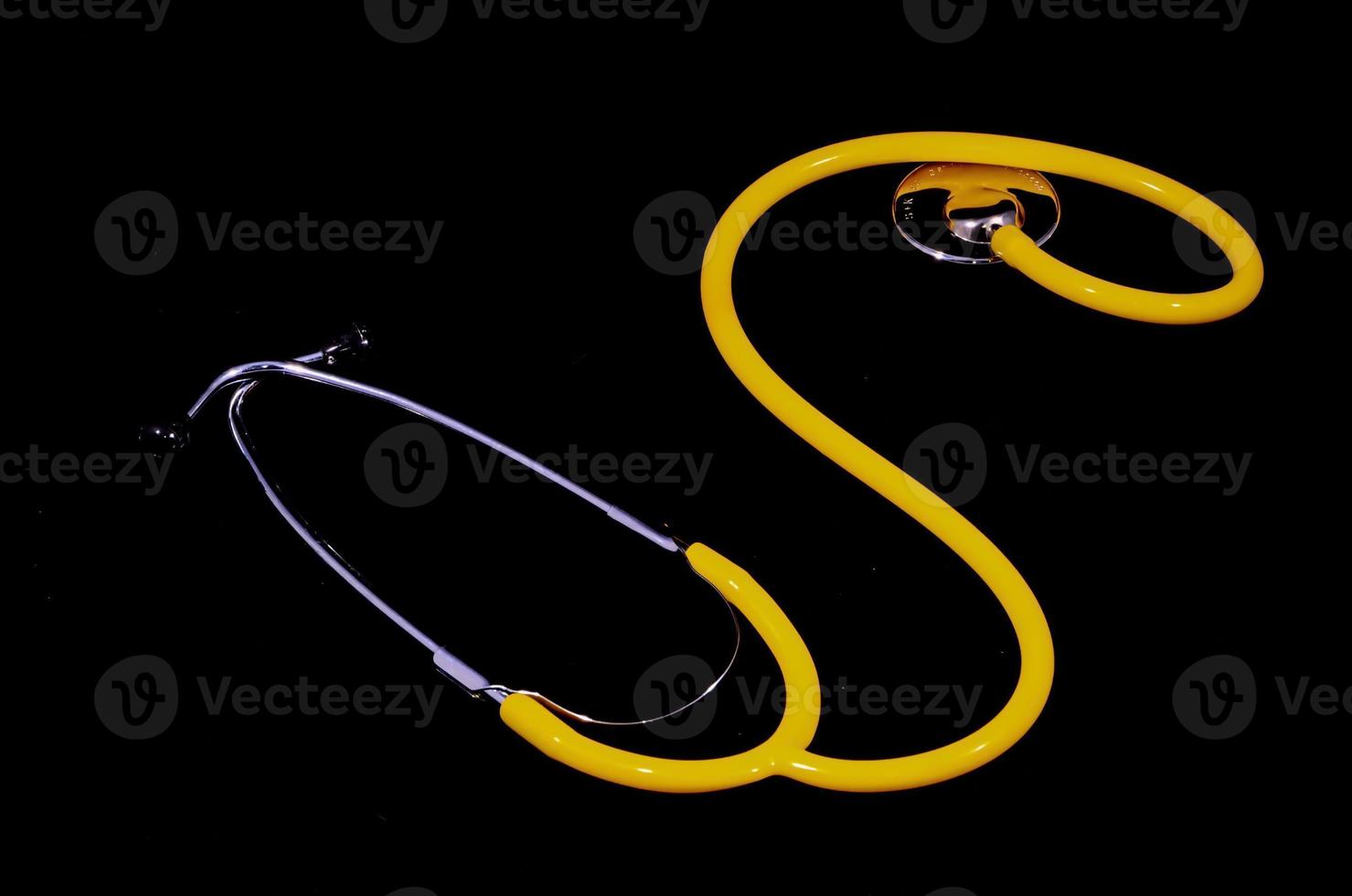 geel stethoscoop Aan zwart achtergrond foto