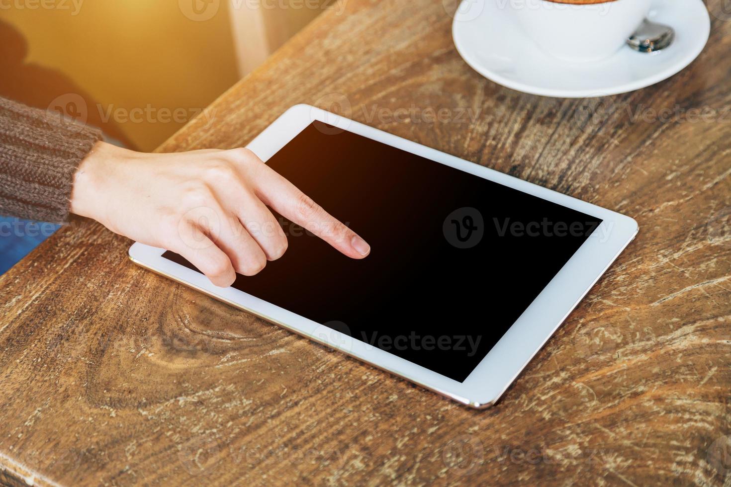 vrouw Speel tablet computer in koffie winkel met wijnoogst afgezwakt. foto