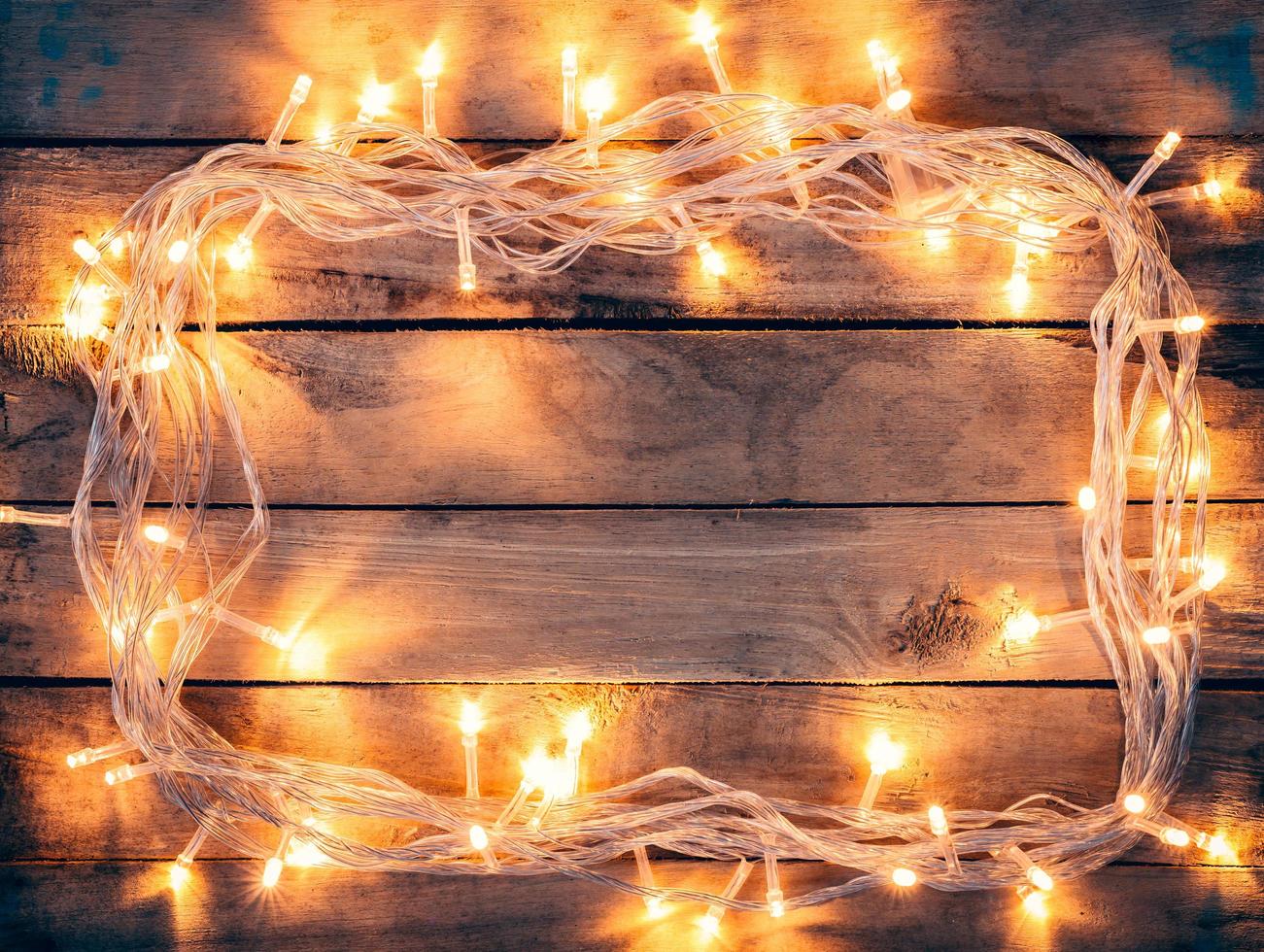 Kerstmis decoratie achtergrond - wijnoogst planken hout met lichten met kopiëren ruimte tekst. foto