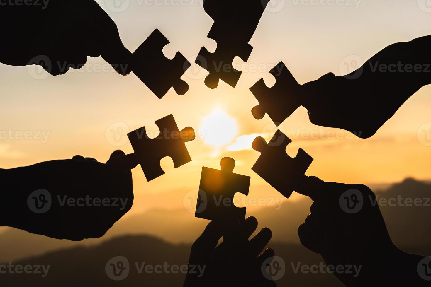 silhouet handen Verbinden decoupeerzaag puzzel stuk tegen zonsopkomst, bedrijf oplossingen, teamwerk, vennootschap, succes, doelen en strategie concepten. foto