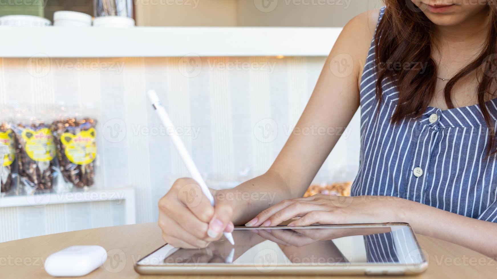 jong vrouw Holding een stylus in haar hand- naar gebruik langs met toepassing in tablet naar test en ontwikkelen ux ui systeem en naar ontwerp toepassing dat kan werk efficiënt met perfect ux ui systeem. foto