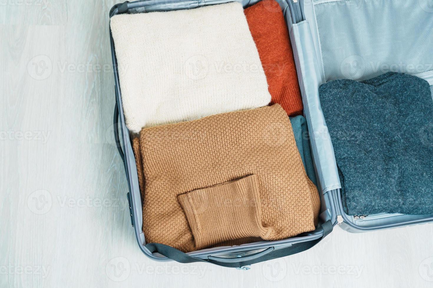 winter kleren in bagage. tijd naar reis, reis, kom tot rust, voorjaar of herfst of winter seizoen en vakantie concepten foto
